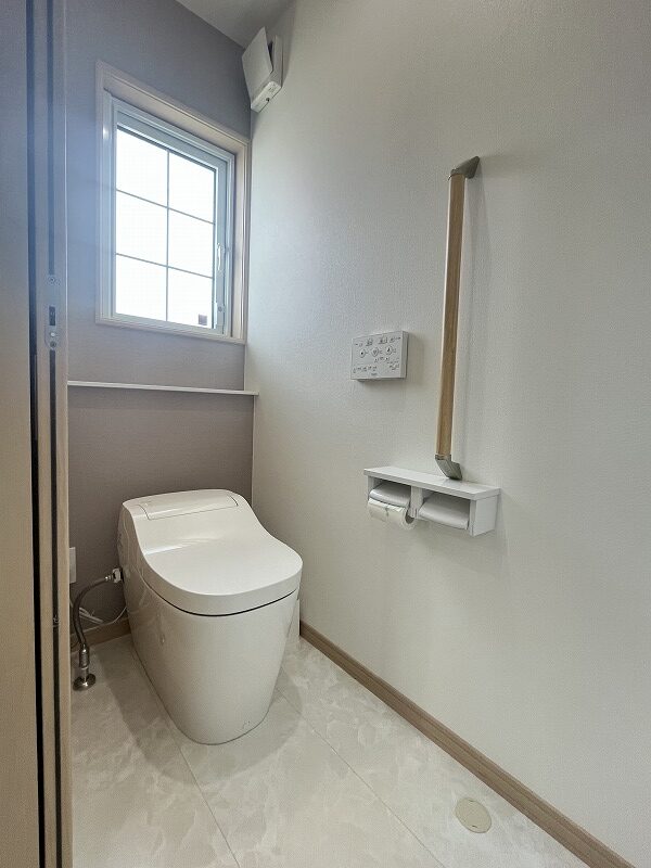 下関市小月市原町の省エネ住宅 節水型タンクレストイレと手すり付きの清潔感あるトイレスペース

